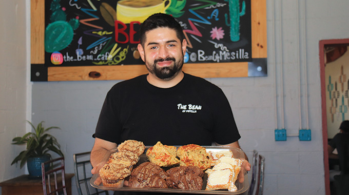 The Owner of the bean cafe holding a tray of balderas-with-pasteries